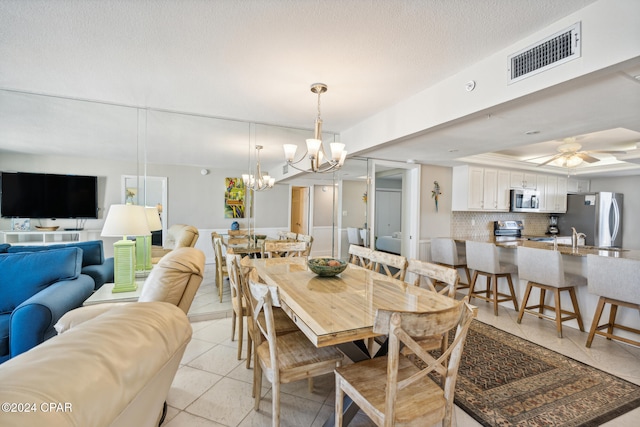 tiled dining area with ceiling fan with notable chandelier