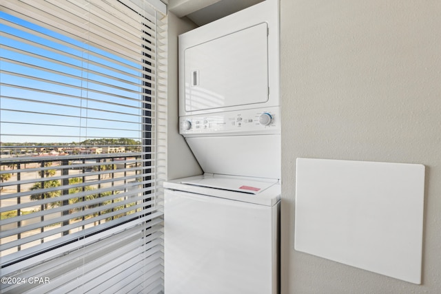 clothes washing area with stacked washer / dryer