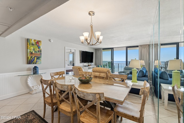 tiled dining area featuring a wall of windows and an inviting chandelier