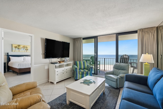 tiled living room featuring floor to ceiling windows and a textured ceiling