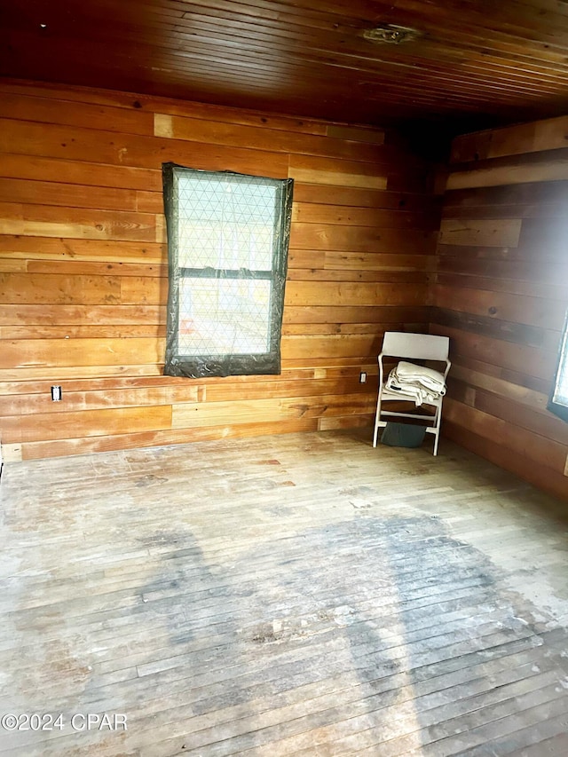 unfurnished room with hardwood / wood-style flooring, wood walls, and wooden ceiling