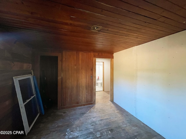 empty room featuring wood ceiling and wooden walls