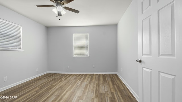 empty room with hardwood / wood-style floors and ceiling fan