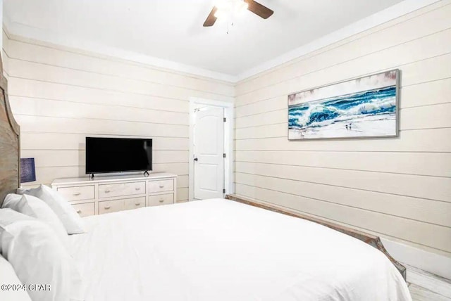 bedroom with ceiling fan and wooden walls