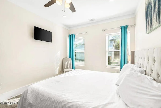 bedroom with hardwood / wood-style floors, ceiling fan, and crown molding