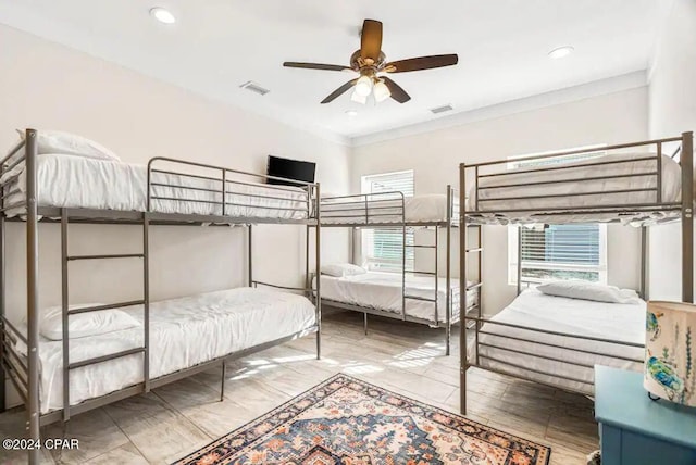 bedroom with ceiling fan and crown molding