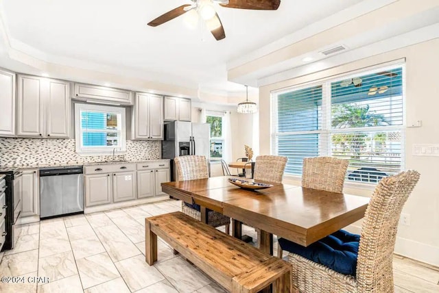 dining room with ceiling fan and sink