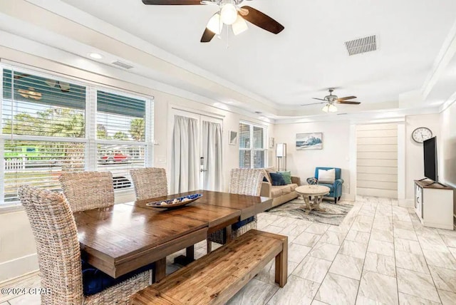 dining area with ceiling fan, crown molding, and a tray ceiling