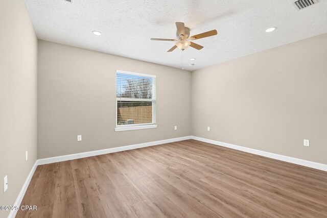 spare room with ceiling fan, hardwood / wood-style floors, and a textured ceiling