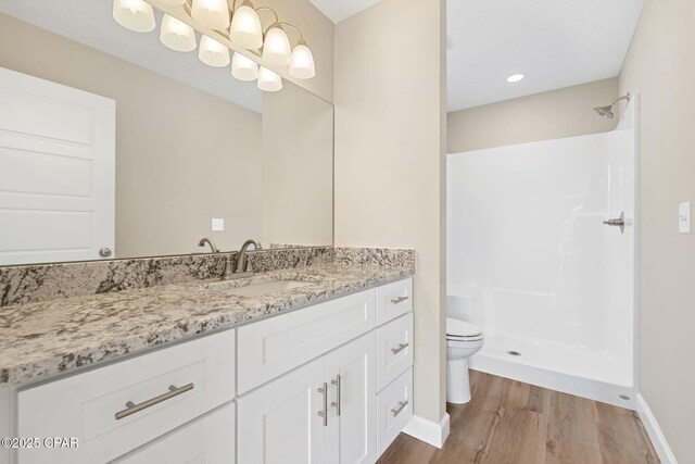 bathroom featuring walk in shower, vanity, toilet, and hardwood / wood-style flooring