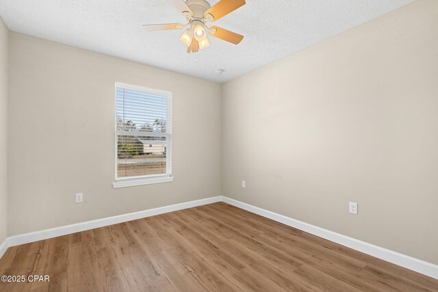 unfurnished room with ceiling fan, wood-type flooring, and a textured ceiling