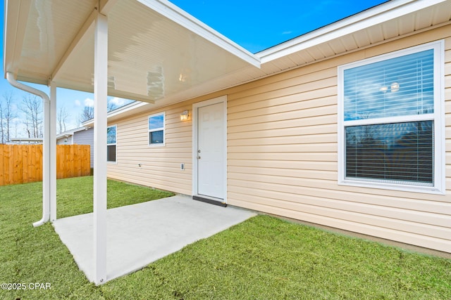 doorway to property featuring a lawn and a patio