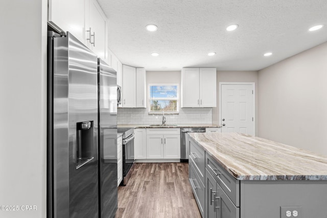 kitchen featuring gray cabinets, white cabinetry, stainless steel appliances, and dark wood-type flooring