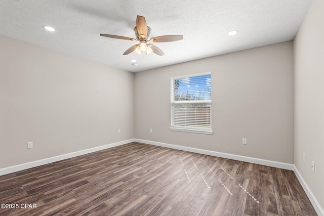 empty room with dark wood-style floors, ceiling fan, a textured ceiling, and baseboards