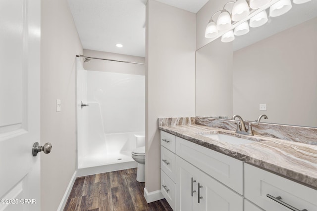 full bathroom featuring a shower stall, vanity, toilet, and wood finished floors