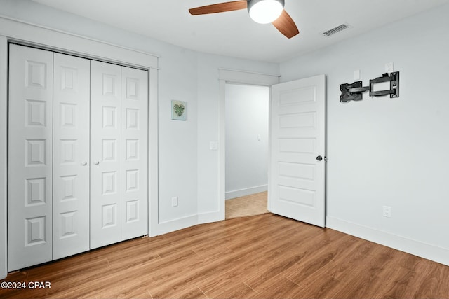 unfurnished bedroom featuring ceiling fan, a closet, and light wood-type flooring