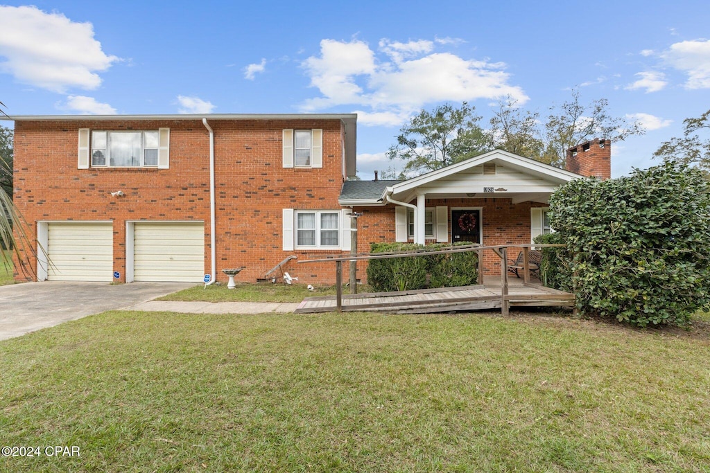 view of front of property with a garage, a front lawn, and covered porch