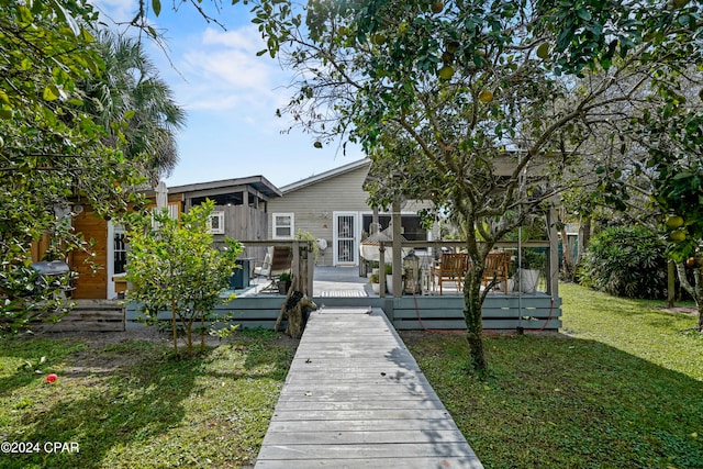 rear view of house with a lawn and a deck