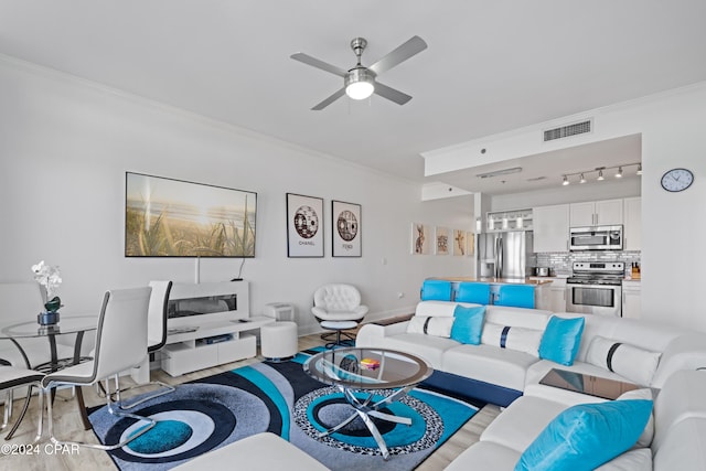 living room featuring crown molding, ceiling fan, and light wood-type flooring