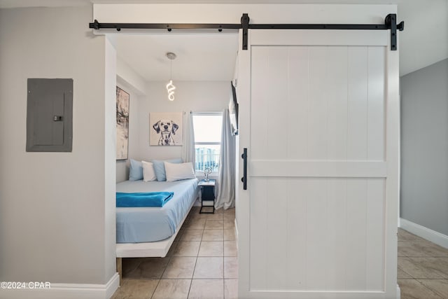 tiled bedroom featuring a barn door and electric panel