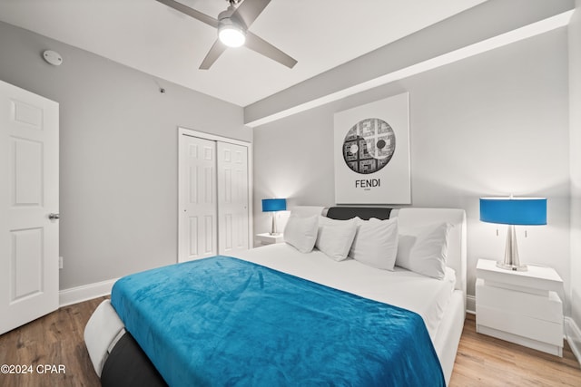 bedroom featuring hardwood / wood-style flooring, ceiling fan, and a closet