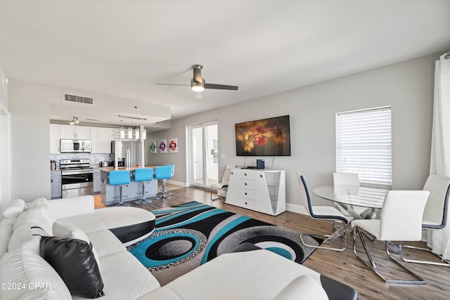 living room with ceiling fan and wood-type flooring