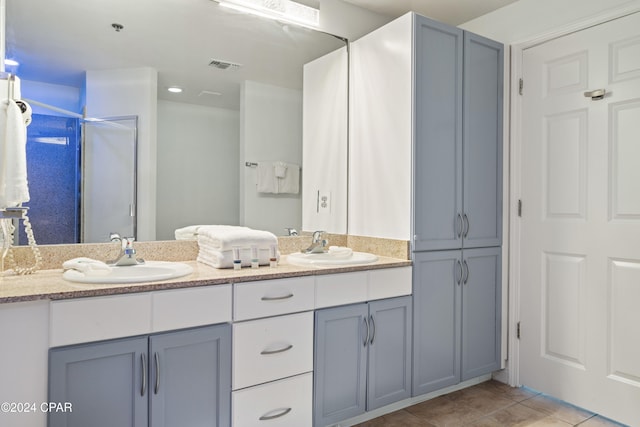 bathroom with tile patterned flooring, a shower, and vanity