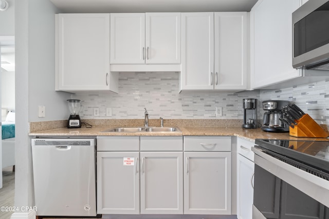 kitchen with tasteful backsplash, white cabinetry, sink, and appliances with stainless steel finishes