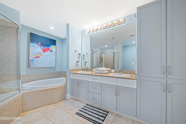 bathroom featuring plus walk in shower, vanity, and tile patterned flooring