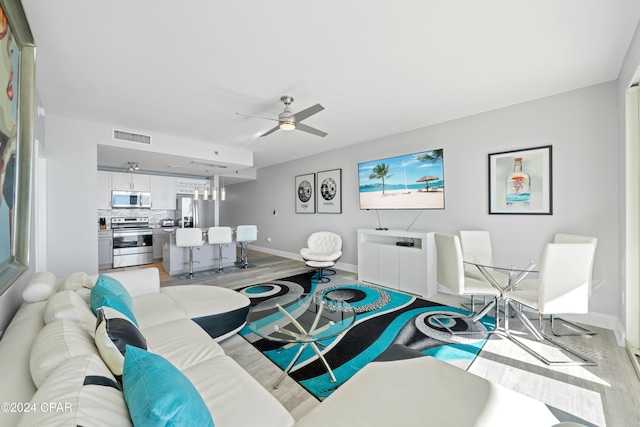 living room featuring ceiling fan and light hardwood / wood-style floors