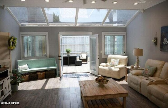 living room featuring a skylight, ceiling fan, and hardwood / wood-style floors