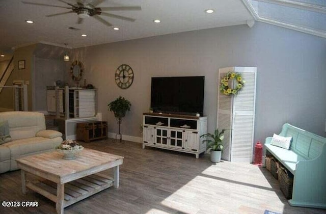 living room featuring ceiling fan, wood-type flooring, and vaulted ceiling