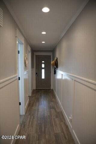 hall featuring crown molding and dark wood-type flooring