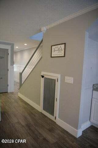 interior space featuring wood-type flooring and crown molding