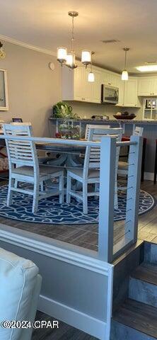 dining space featuring ornamental molding and hardwood / wood-style flooring