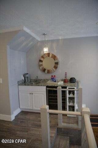 bar with white cabinets, dark hardwood / wood-style flooring, lofted ceiling, and a textured ceiling