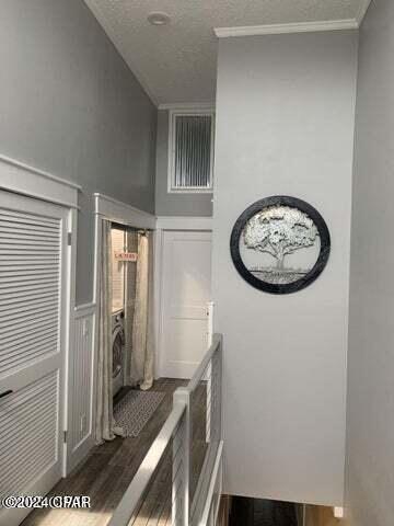 interior space with crown molding, dark wood-type flooring, and a textured ceiling