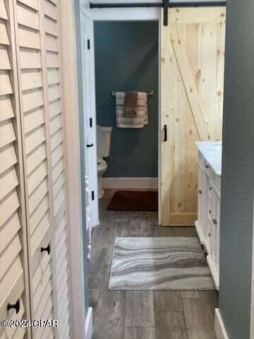 bathroom with hardwood / wood-style floors, vanity, and toilet