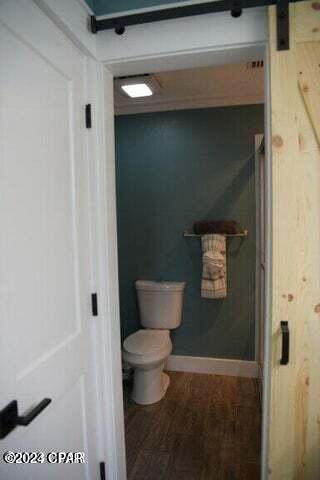 bathroom featuring wood-type flooring and toilet