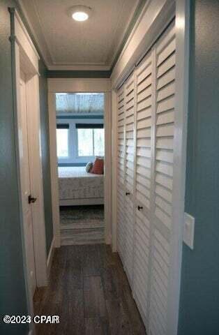 corridor featuring dark hardwood / wood-style flooring and ornamental molding