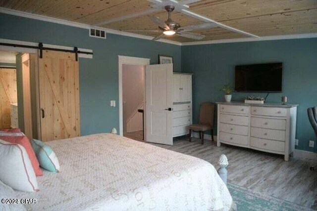 bedroom featuring a barn door, hardwood / wood-style flooring, wood ceiling, and ornamental molding