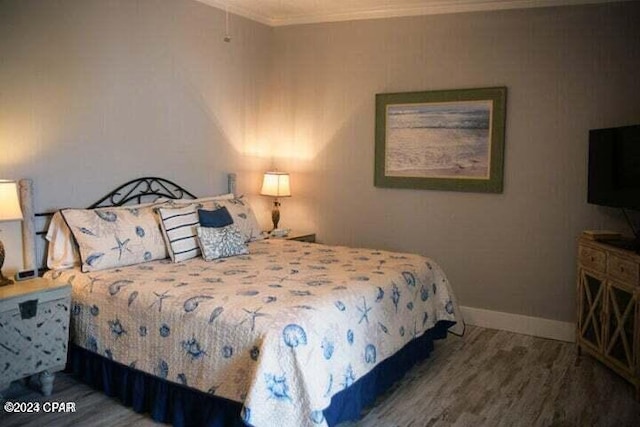 bedroom featuring crown molding and hardwood / wood-style floors