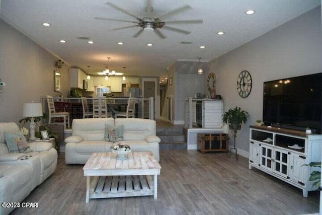 living room with hardwood / wood-style floors and ceiling fan with notable chandelier