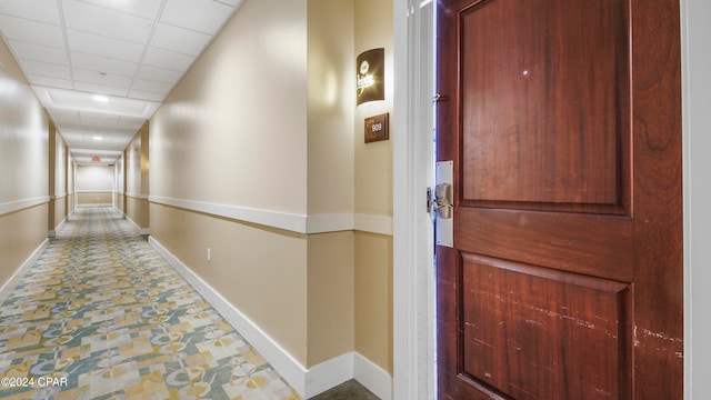 corridor with a paneled ceiling