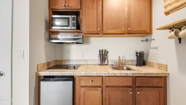 kitchen featuring black electric stovetop, sink, and extractor fan