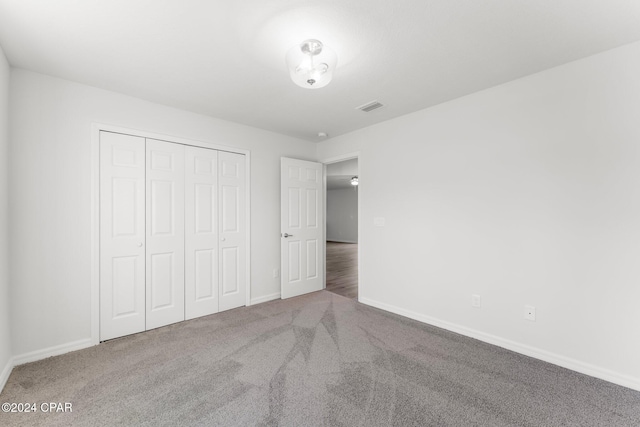 unfurnished bedroom featuring carpet and a closet