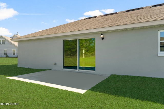 rear view of property featuring a lawn