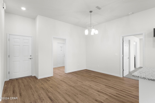 kitchen featuring hardwood / wood-style floors, ceiling fan with notable chandelier, plenty of natural light, and an island with sink