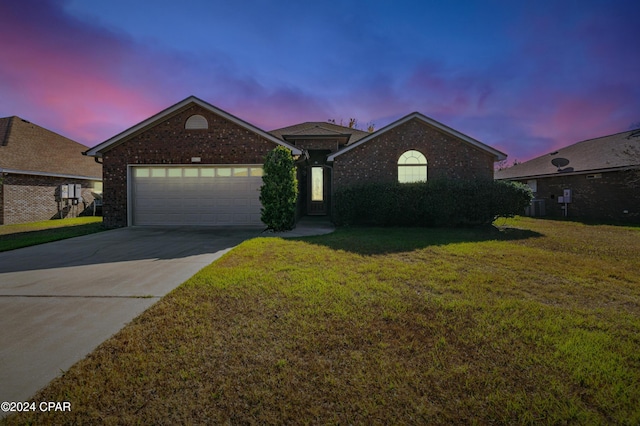 view of front of house featuring a lawn, cooling unit, and a garage