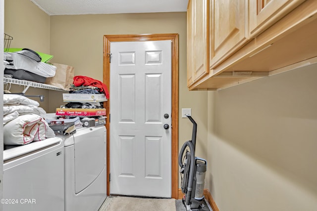 washroom with cabinets, light colored carpet, and washing machine and dryer